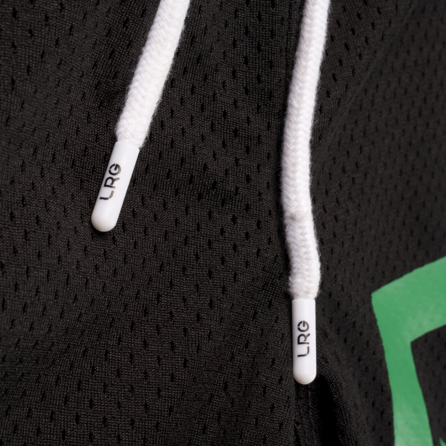 Close-up of a black hoodie with white drawstrings and green lettering.