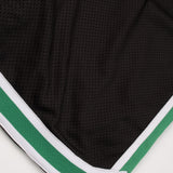 Black athletic shorts with green and white trim on a white background