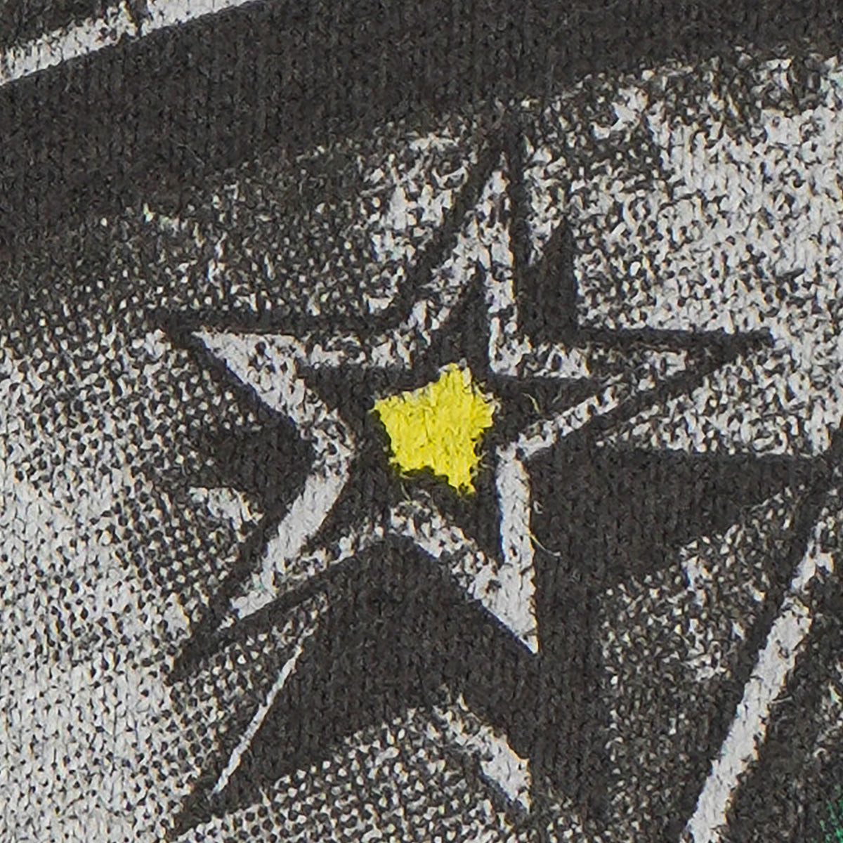 Close-up of a star design with a yellow center on a textured surface.