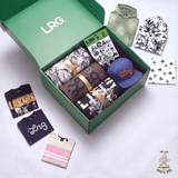 An open green LRG. box filled with folded apparel and accessories, surrounded by matching clothing laid out on a white background.